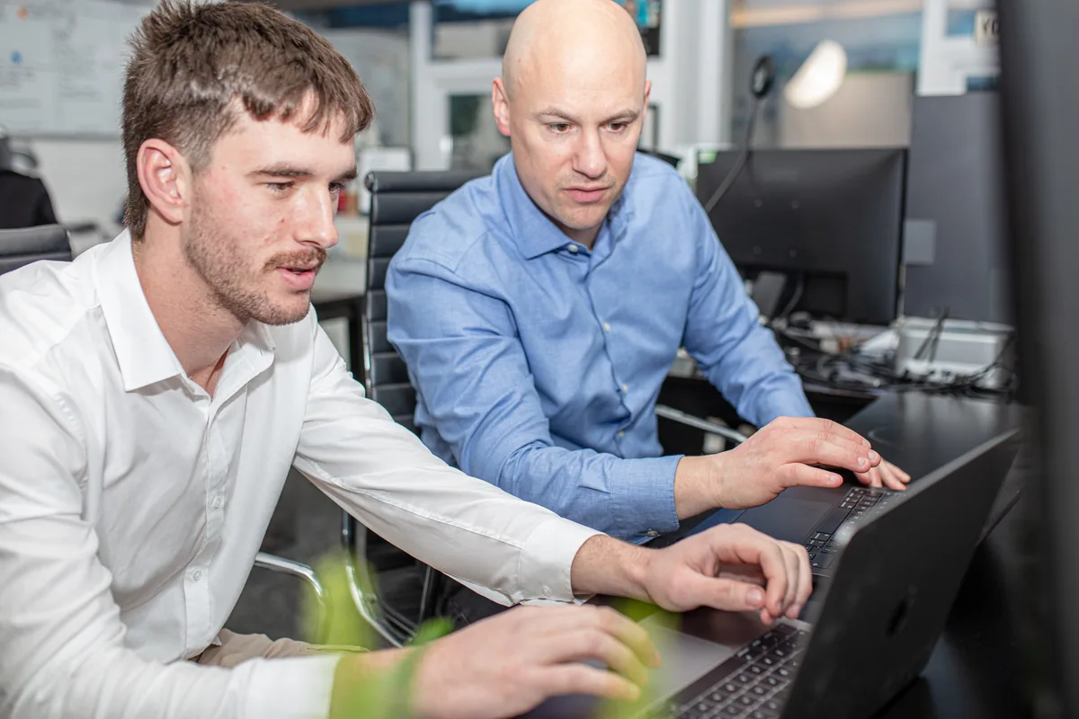 David and Luke from Halizona working at a laptop in the office